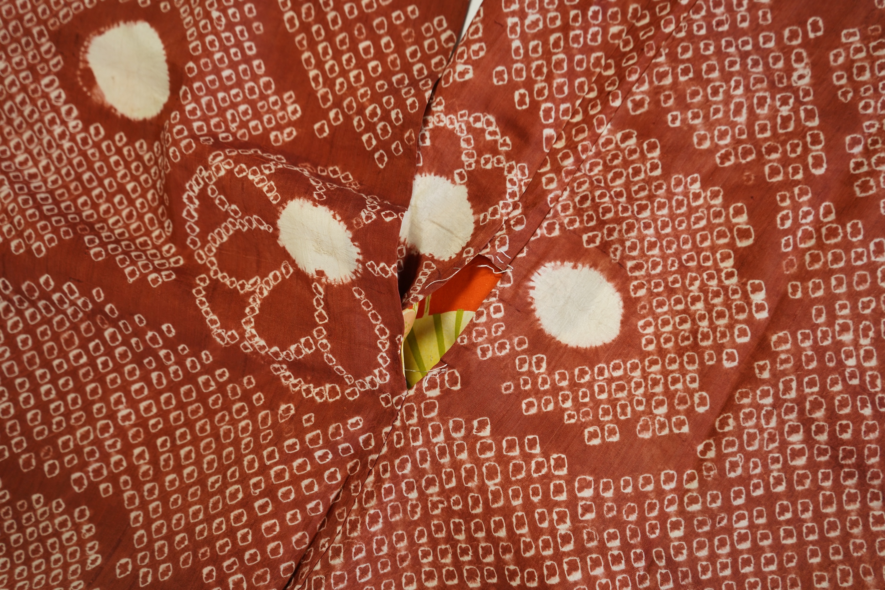 Three Japanese mid 20th century ‘Haori’ printed silk jackets. One red with brightly coloured lining and rust brown floral silk lining. All with large kimono sleeves. Grey patterned Haori, 79cm long., Condition - good